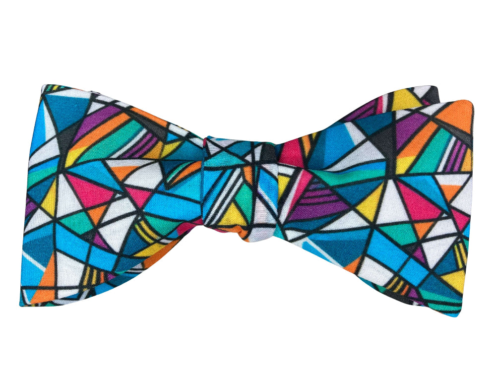 A bow tie featuring a vibrant, multicolored geometric pattern of triangles and angular shapes outlined in black.