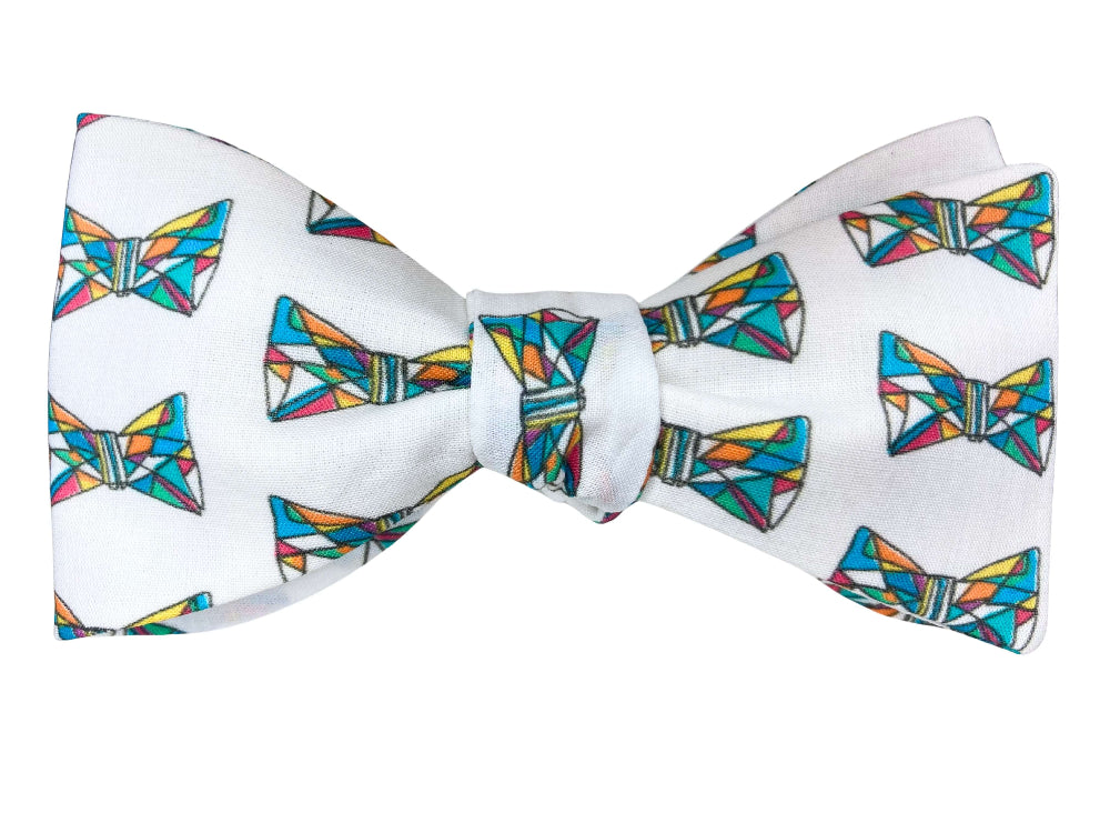 A white self-tie bow tie featuring a repeating pattern of colorful geometric bow tie motifs in shades of blue, green, yellow, and orange.