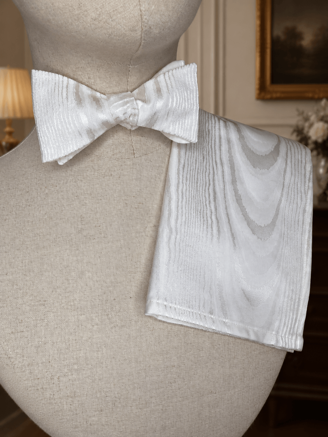 White bow tie and pocket square on a mannequin bust.