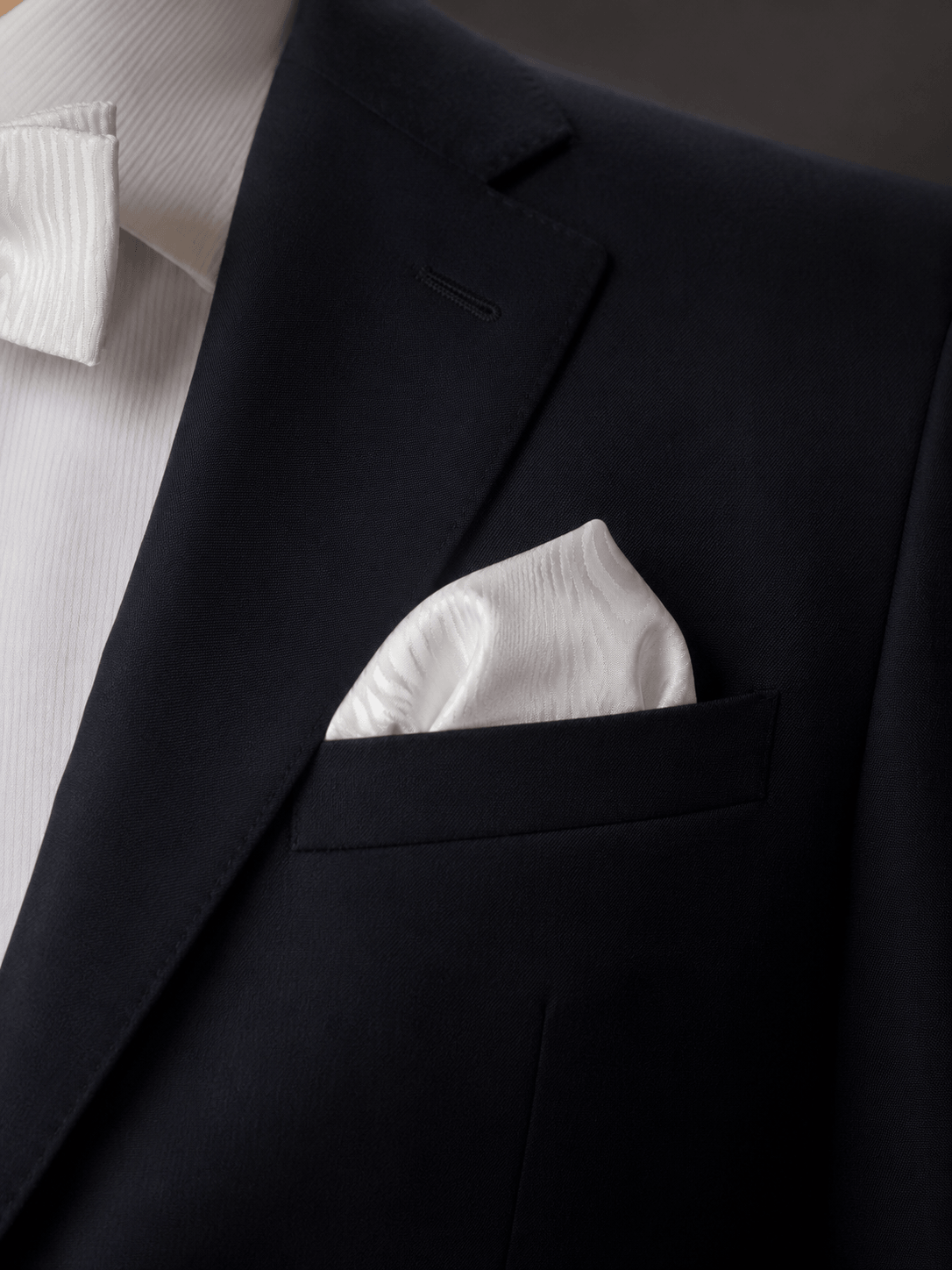 ivory moire silk pocket square folded with a black blazer