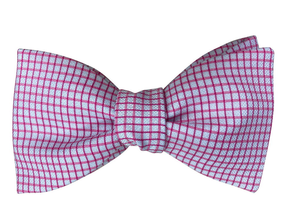 A bow tie featuring a pink and blue micro-checkered pattern
