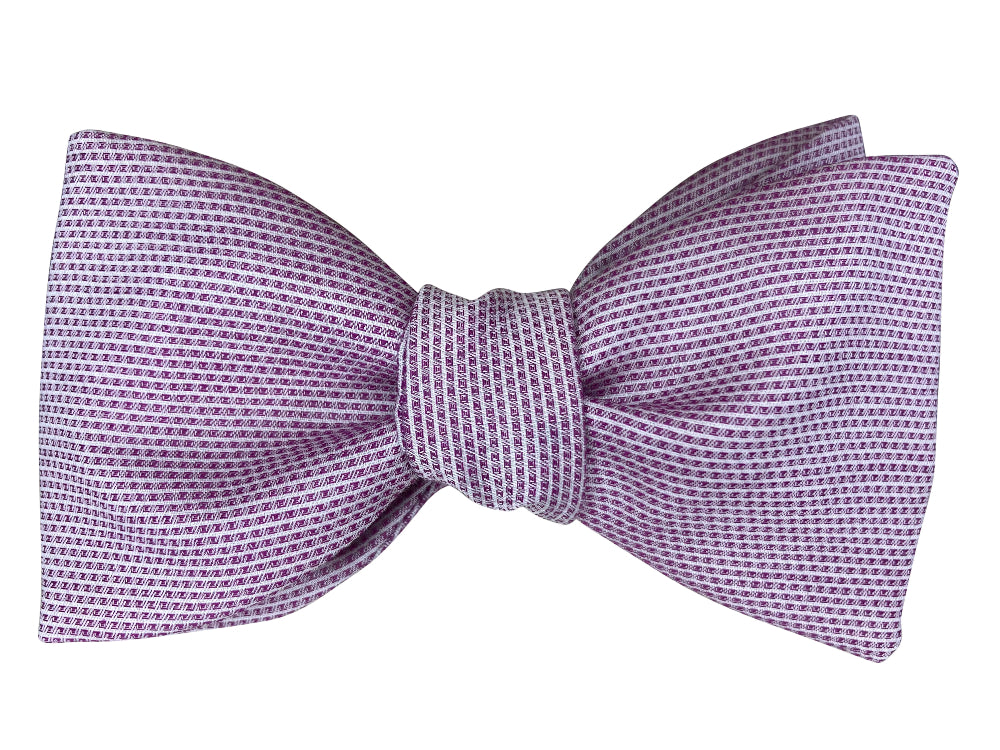 A bow tie with a fine micro-pattern of small purple and white dots